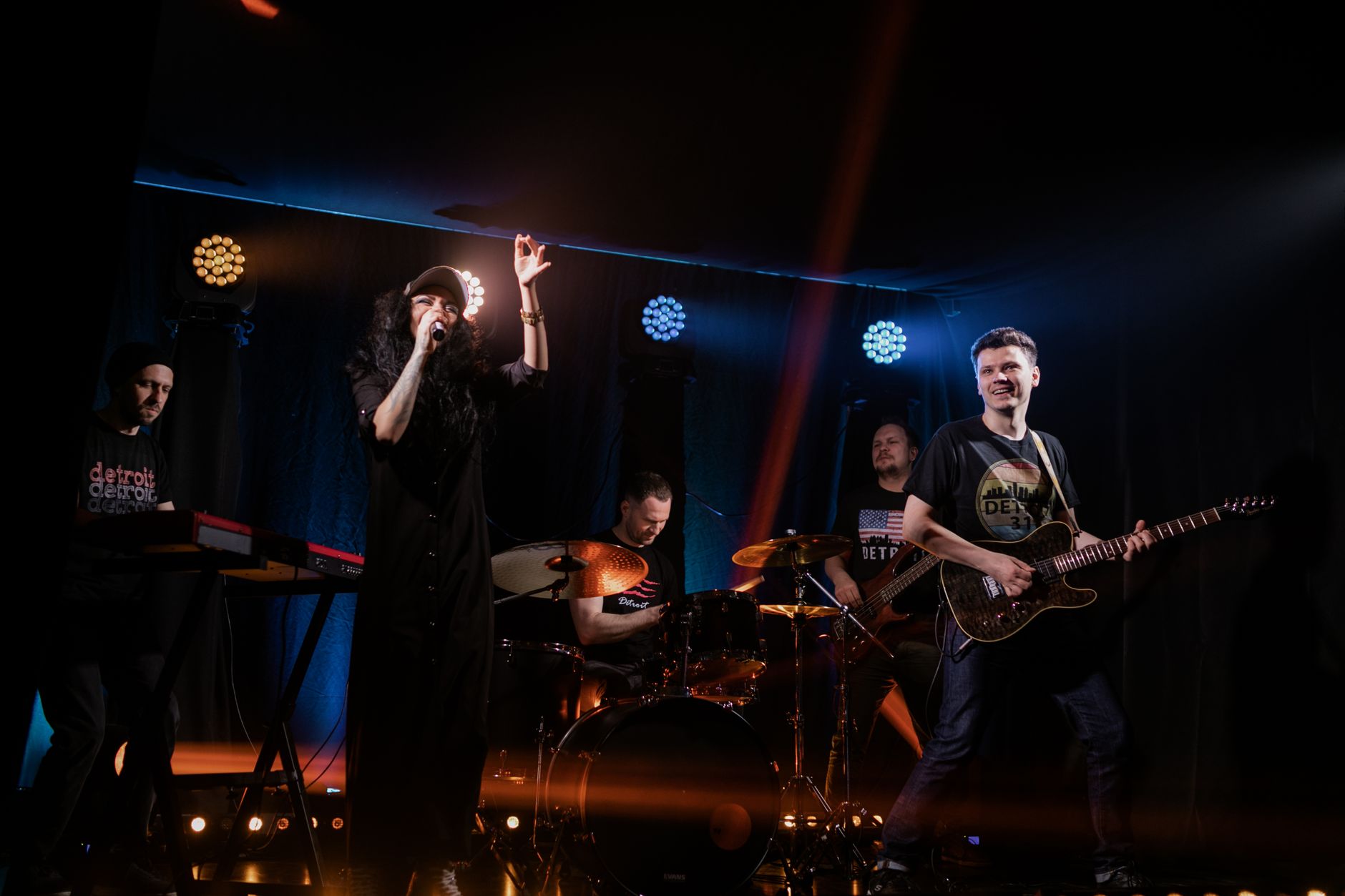 Koncert rockowego zespołu z wokalistą na scenie w energetycznym świetle