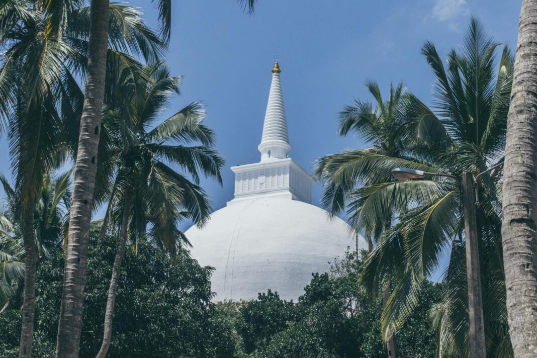 Stupa Mihintale wśród palm na tle błękitnego nieba w Sri Lance Stupa Mihintale wśród palm na tle błękitnego nieba w Sri Lance