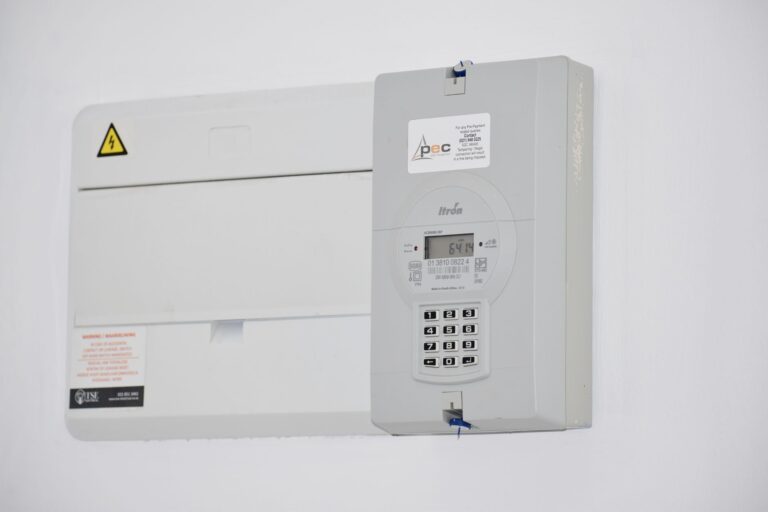 Licznik energii elektrycznej i skrzynka bezpiecznikowa na białej ścianie